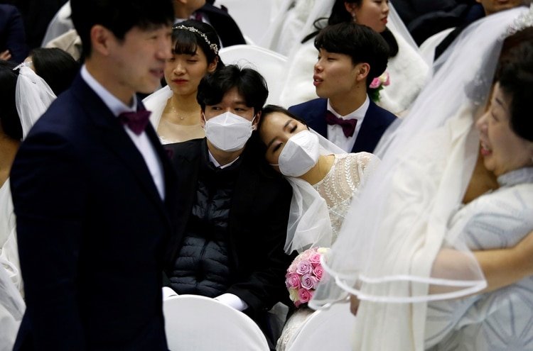 Una pareja usando máscaras para protegerse del coronavirus en una iglesia en Corea del Sur (REUTERS/Heo Ra)