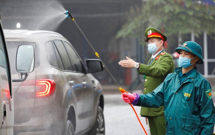 Los autos son desinfectados en el ingreso a Thai Nguyen, en Vietnam - REUTERS/Kham