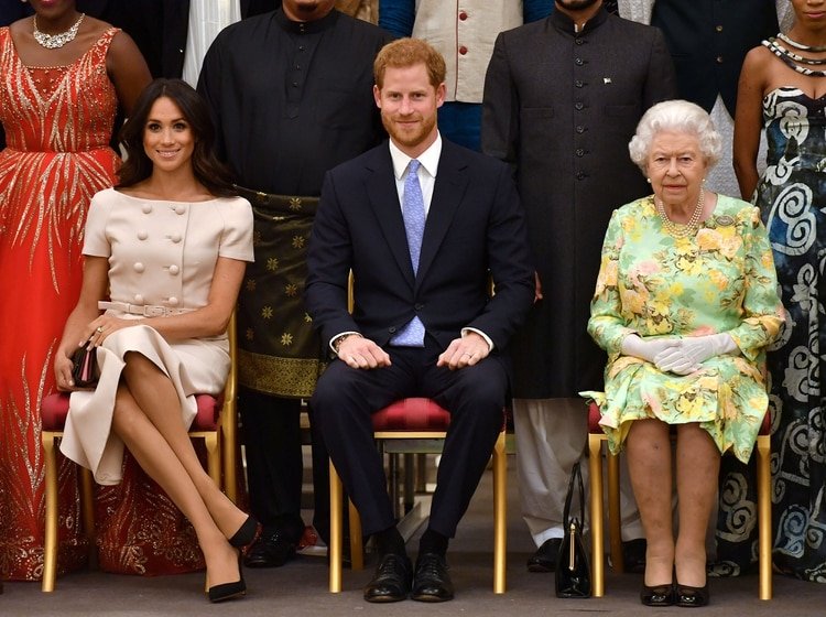 La Reina Isabel de Gran Bretaña, el Príncipe Harry y Meghan, la Duquesa de Sussex posan en el Palacio de Buckingham, el 26 de junio de 2018, cuando los Sussex aún no habían abandonado a la realeza (Reuters)