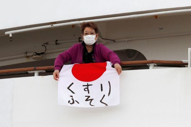 Una mujer sostiene una bandera japonesa que dice 