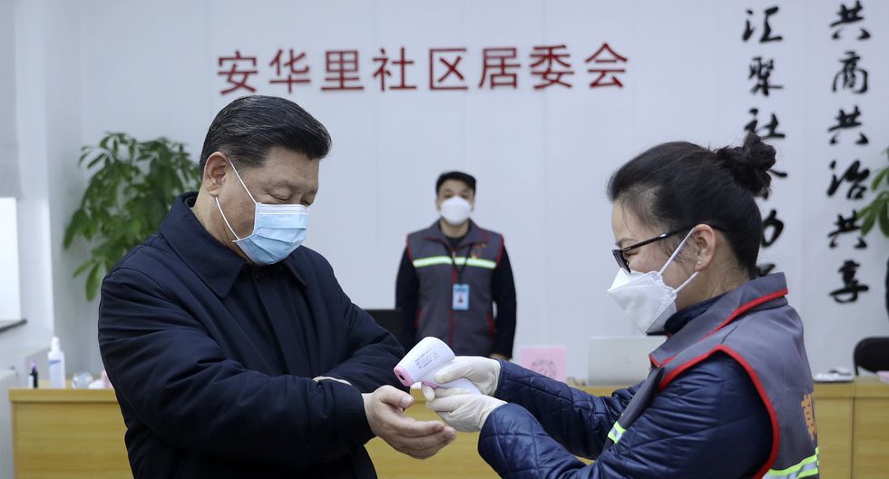 El presidente de China, Xi Jinping, se toma la temperatura durante su visita a un barrio de Beijing, como parte de las medidas para prevenir el contagio del coronavirus de Wuhan. (AP).
