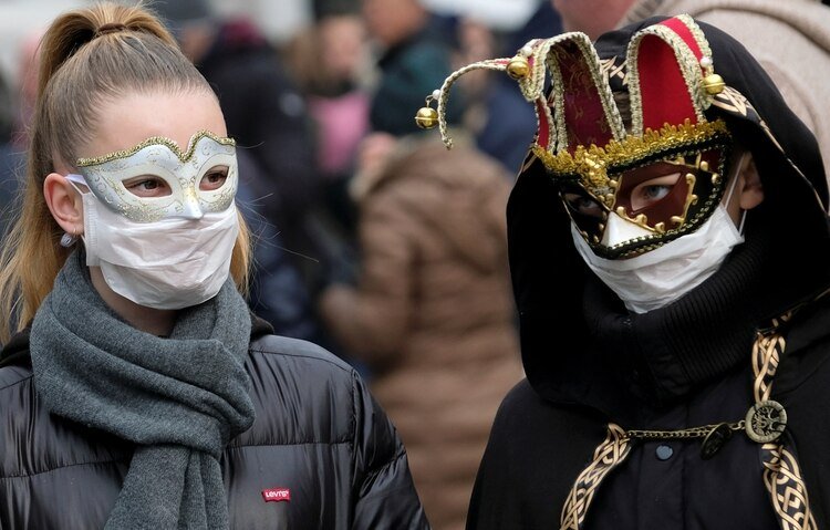 Asistentes al carnaval complementan sus máscaras festivas con barbijos de protección (Reuters)
