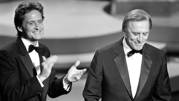 Michael Douglas aplaude a su padre Kirk durante la entrega de los premios Óscar de 1985 (AFP, archivo)
