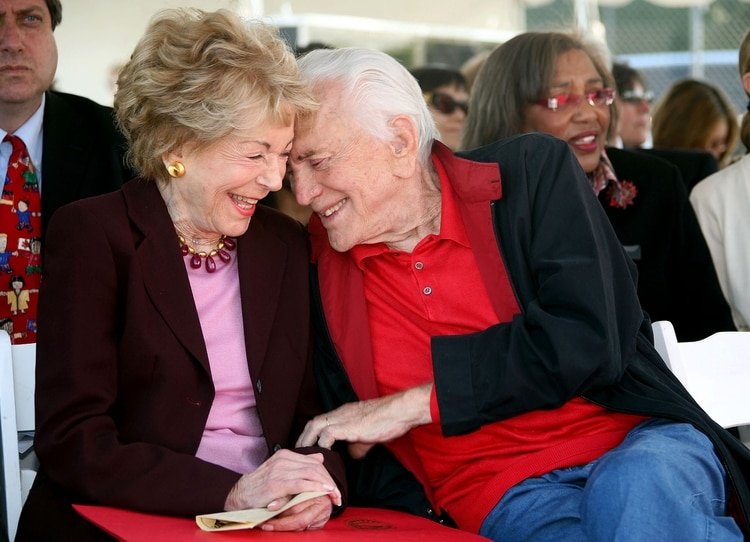 En esta foto de 2008 Kirk y su segunda esposa Anne Buydens asisten a la apertura del patio escolar número 400 en su larga historia de beneficencia (AFP)