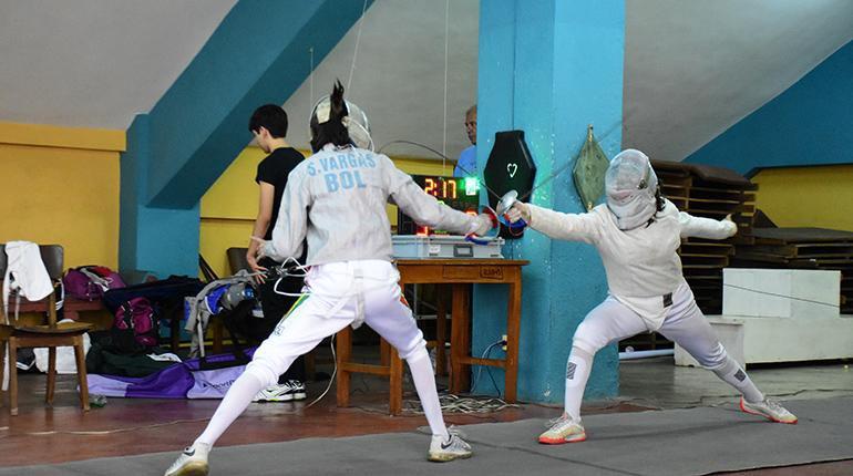 Un par de esgrimistas combaten en un torneo.