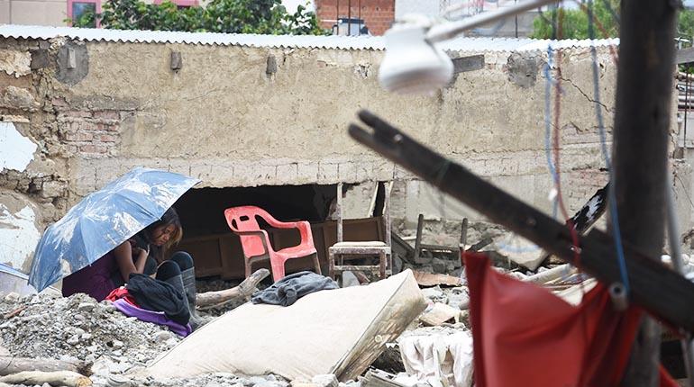 Jóvenes descansan entre escombros y lodo en el Manzano 78. | Daniel James