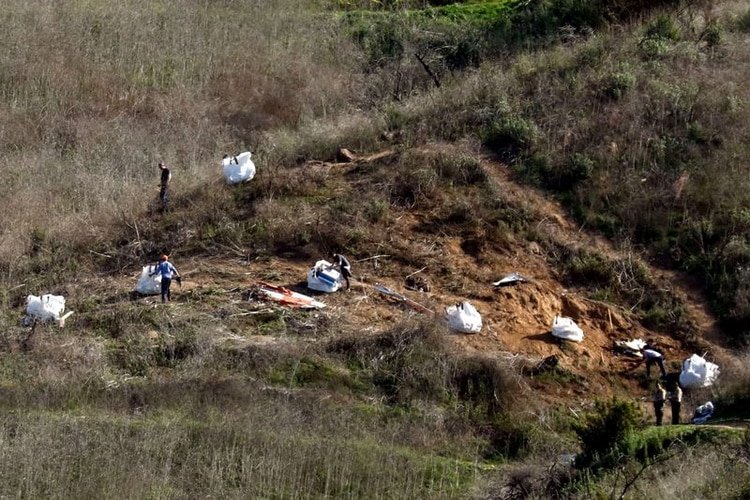 Personal recoge escombros mientras trabaja con investigadores en el lugar del accidente de helicóptero de la estrella de la NBA Kobe Bryant en Calabasas, EEUU, 28 enero 2020 (Reuters)