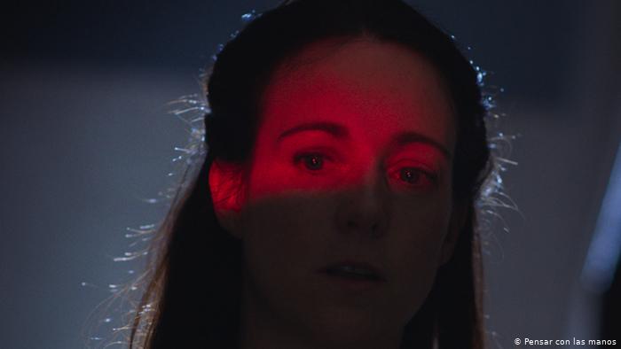 Fotograma de Un crimen común. Cecilia alcanza a ver que es Kevin quien toca con fuerza a su puerta, pero le da miedo abrir. 