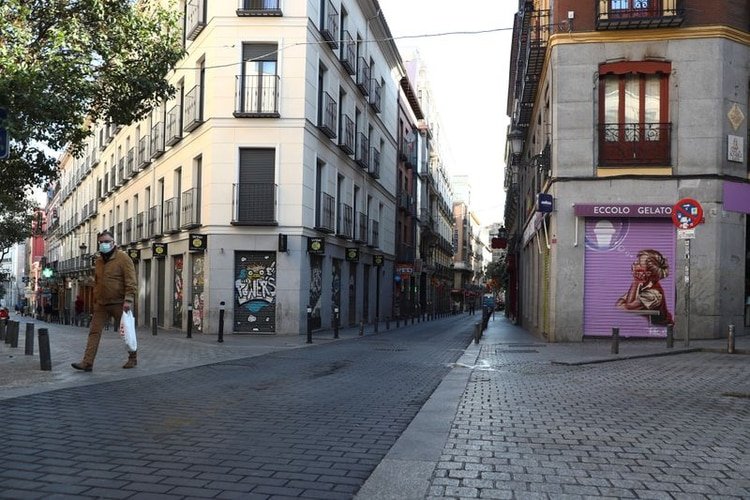 Un hombre con mascarilla camina por una calle vacía debido al brote de coronavirus en el centro de Madrid, España, el 14 de marzo de 2020. REUTERS/Sergio Pérez