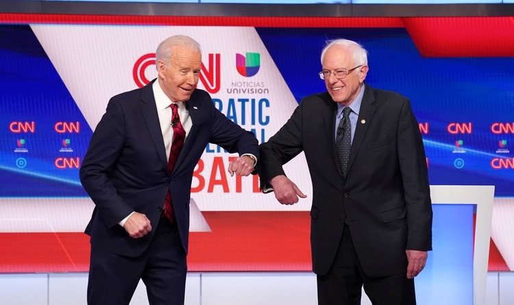 Joe Biden y Bernie Sanders se saludan con el codo en el debate de domingo. REUTERS/Kevin Lamarque 