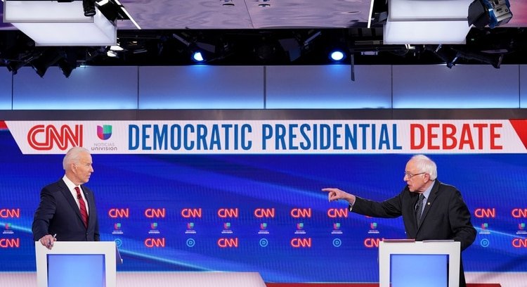 Democratic U.S. presidential candidate former Vice President Joe Biden listens as Senator Bernie Sanders speaks during the 11th Democratic candidates debate of the 2020 U.S. presidential campaign, held in CNN's Washington studios without an audience because of the global coronavirus pandemic, in Washington, U.S., March 15, 2020. REUTERS/Kevin Lamarque