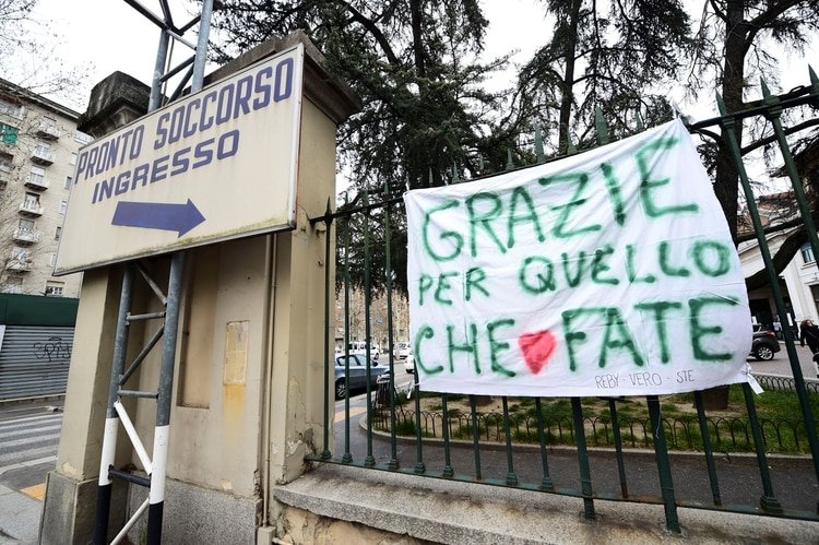 Una bandera de agradecimiento en la entrada de un hospital en Turín (Reuters)