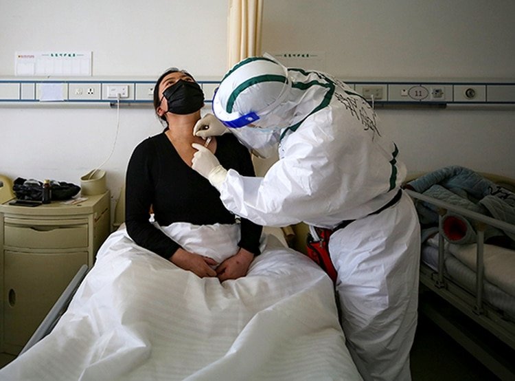 Un paciente con COVID-19 recibe tratamiento con acupuntura en un hospital de la Cruz Roja en Wuhan, China (STR / AFP) 