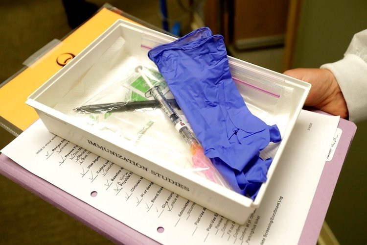 El farmacéutico Michael Witte sostiene una bandeja con una jeringa que contiene una inyección que se utilizó en el ensayo clínico de estudio de seguridad de la primera etapa de una vacuna potencial para COVID-19, la enfermedad causada por el nuevo coronavirus chinio (AP)