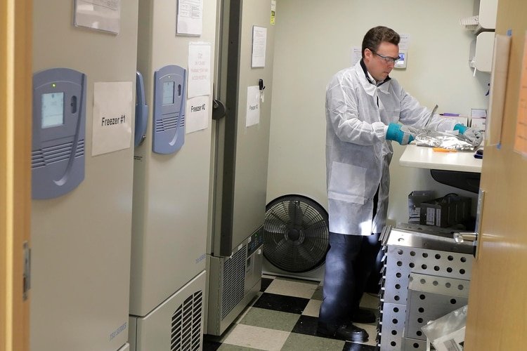 Michael Witte abre un paquete de la vacuna potencial para COVID-19, la enfermedad causada por el nuevo coronavirus chino (AP)