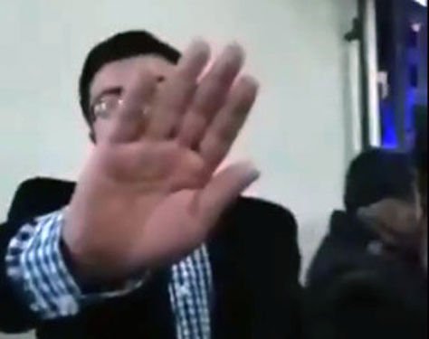 El exviceministro sale del edificio e intenta cubrirse en medio de la grabación del video.