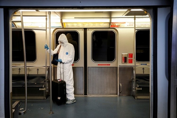 Una mujer con equipo de protección en el tren del aeropuerto JFK en Nueva York (Reuters)