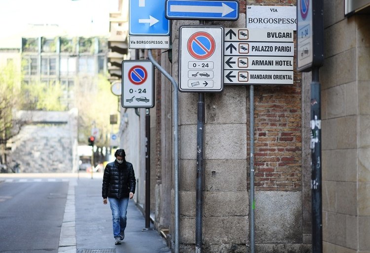 Una mujer con una máscara facial protectora camina por una calle de Milán mientras continúa la propagación del coronavirus, el 21 de marzo de 2020. (REUTERS/Daniele Mascolo)