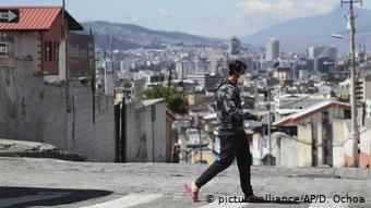 Foto de un hombre caminando con mascarilla en Quito