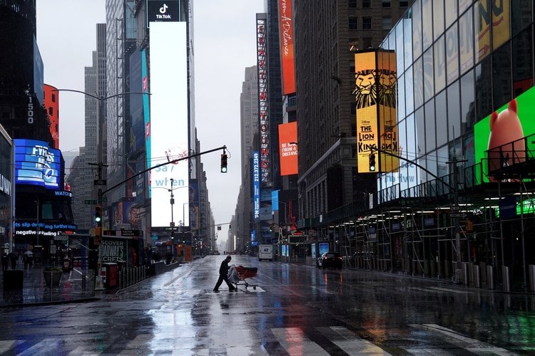 Una persona sin hogar empuja sus pertenencias a través de un Times Square desierto después del brote de la enfermedad por coronavirus, en el distrito de Manhattan, Nueva York (Reuters)