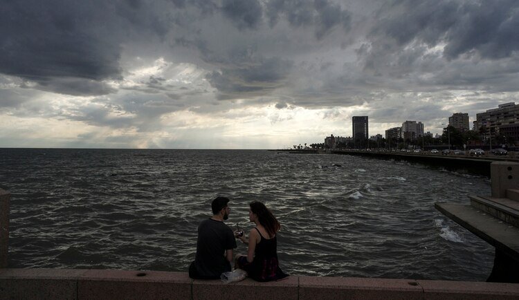 Una pareja comparte un mate en la Rambla de Montevideo (AFP)