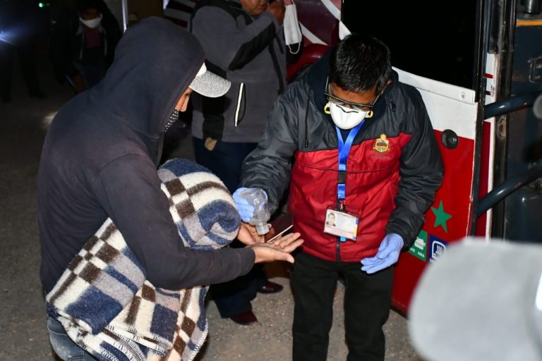 Un boliviano que cruzó la frontera por Pisiga, recibe una ración de alcohol en gel, antes de subir a un bus. Foto: Gobernación de Oruro.