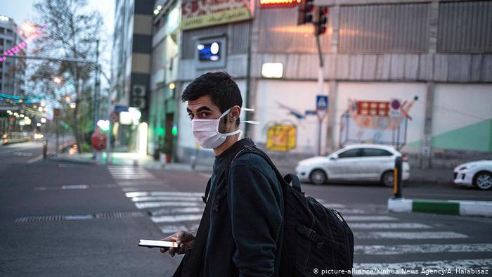 Un hombre con tapabocas camina por una calle de Teherán.