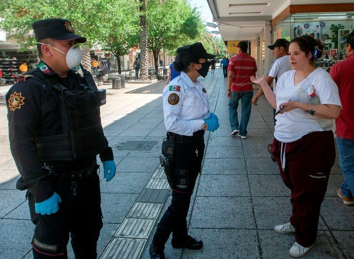 Policías avisan a peatones que regresen a sus casas en Monterrey, Nuevo León, Mexico,(Photo by Julio Cesar AGUILAR / AFP)