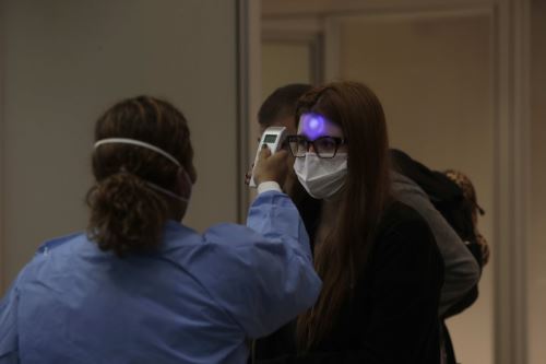 Profesionales de vigilancia sanitaria miden la temperatura a los pasajeros y tripulantes que desembarcan en el Aeropuerto Internacional de Galeão, en Río de Janeiro (Brasil) coronavirus