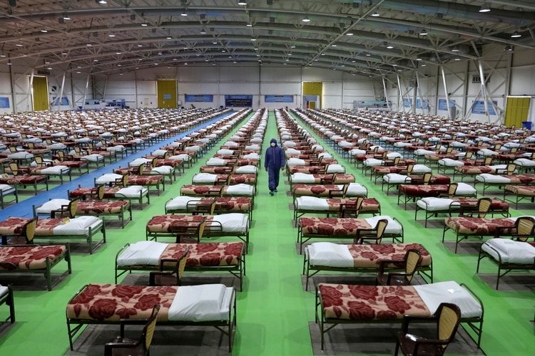 Un miembro del ejército de Irán camina entre las filas de camas de un hospital temporal de 2.000 camas para atender a los pacientes de COVID-19, instalado por el ejército en un centro de exhibiciones en el norte de Teherán, en Irán, el 26 de marzo de 2020. (AP Foto/Ebrahim Noroozi)