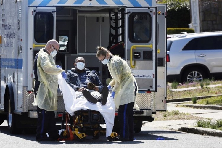 Técnicos de emergencias médicas llevan a un paciente con enfermedad por coronavirus (COVID-19) a una ambulancia mientras usan equipo de protección en la ciudad de Nueva York. 26 de marzo de 2020. REUTERS/Stefan Jeremiah