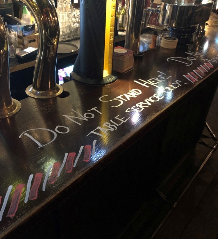 Vista de un mensaje de advertencia: los clientes no pueden mantenerse en pie en el bar y deben sentarse en las mesas para ser atendidos durante el brote de coronavirus, en un pub en Estocolmo (Reuters)
