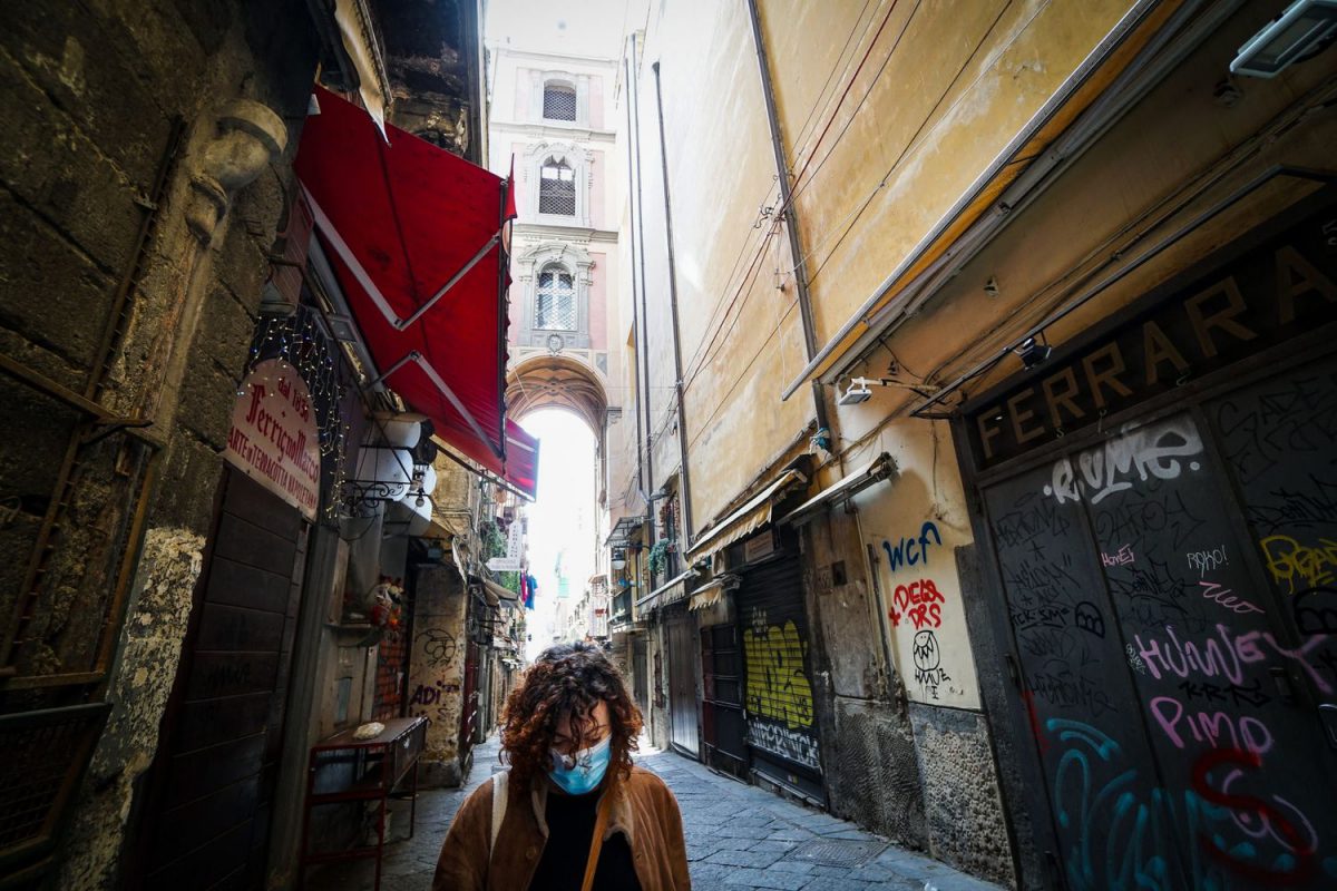 Una mujer con una mascarilla camina por el desértico centro de Nápoles este lunes.