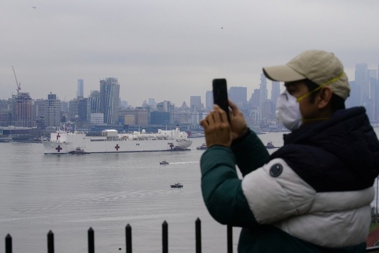 Un hombre registra la llegada a Nueva York del buque hospital USNS Comfort (Reuters)