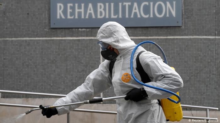 Un miembro de la Unidad Militar de Emergencias (UME) rocía desinfectante para prevenir la propagación del COVID-19 en el Hospital Cabuenes, Gijón, España