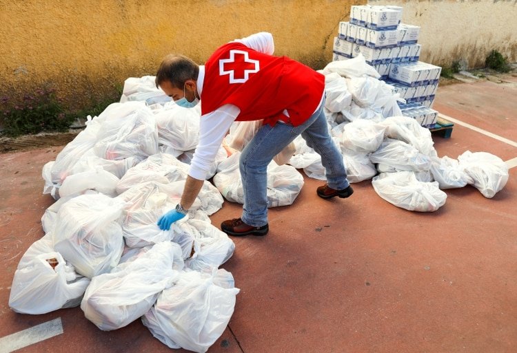 Un miembro de la Cruz Roja Española prepara alimentos para familias necesitadas en un banco de alimentos, como parte de una campaña especial de distribución durante el brote de COVID-19 en Ronda, al sur de España, el 3 de abril de 2020. (REUTERS/Jon Nazca)