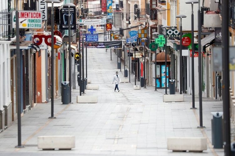 Un empleado de una farmacia camina en una calle vacía en Ronda, en medio del brote de la enfermedad COVID-19 causada por el coronavirus, en el sur de España. 30 de marzo, 2020. REUTERS/Jon Nazca