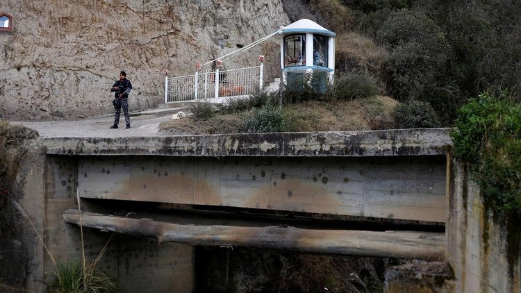 Un oficial de policía ecuatoriano se asoma al lado del camino para observar un paso ilegal en la frontera entre Ecuador y Colombia. 