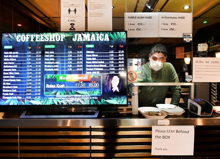 El empleado de un conffe shop atiende detrás de un vidrio protector (REUTERS/Piroschka van de Wouw)