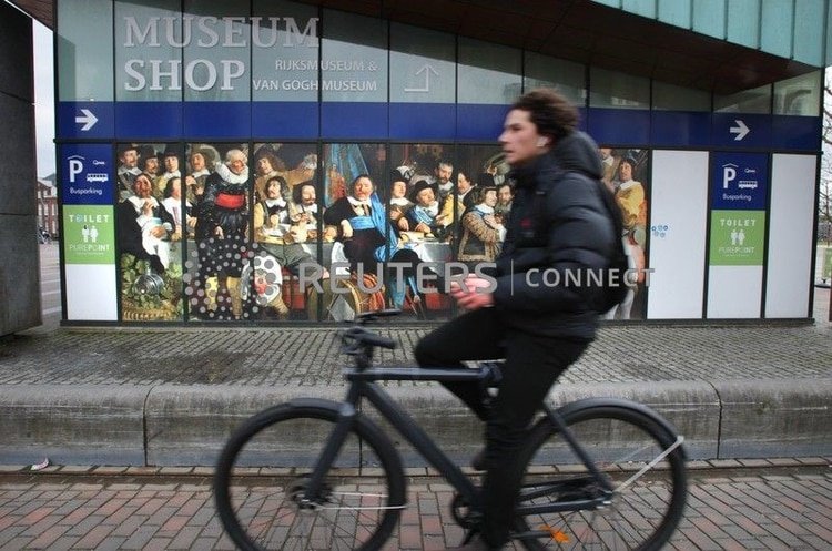Un joven pasa en bicicleta frente a la tienda del museo de Van Gogh, que cerró el 13 de marzo de 2020, en Ámsterdam, Holanda (Photo by Paulo Amorim/Sipa USA)) 