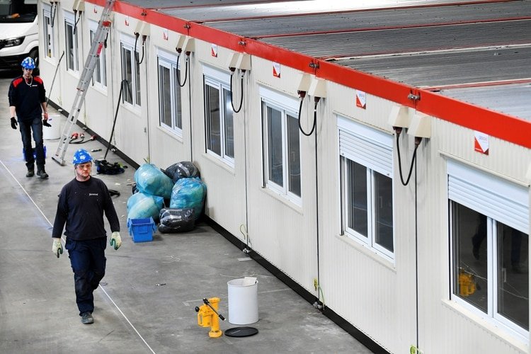 Operarios caminan cerca de las unidades dentro de la sala de conciertos Ahoy, se utiliza como hospital de emergencia en Rotterdam, el 30 de marzo de 2020. (REUTERS/Piroschka Van De Wouw)