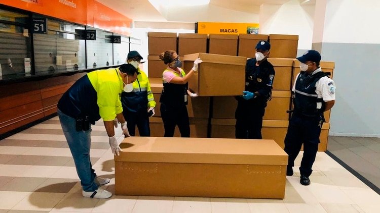 Ataúdes de cartón son almacenados este sábado en la terminal terrestre de Guayaquil (EFE)