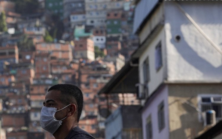 Un hombre con un barbijo espera un autobús en la Rocinha, la favela más grande de Brasil (REUTERS/Ricardo Moraes)
