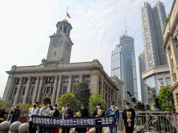 Una ceremonia en silencio de homenaje a los fallecidos frente a la aduana de Hankou en Wuhan, donde la bandera china está izada a meda asta. 