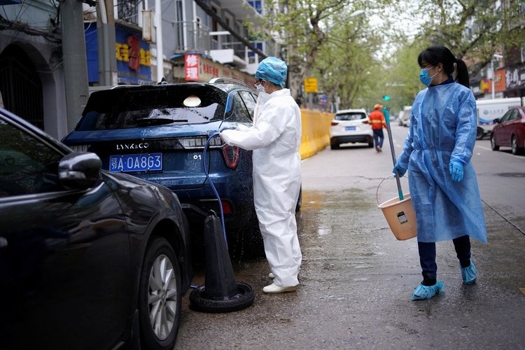 Un hombre lava un automóvil en las calles de Wuhan. (Reuters)