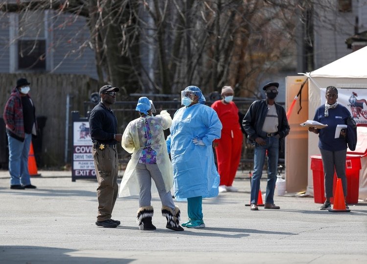Trabajadores médicos hablan con personas que esperan en fila para recibir pruebas durante el brote mundial del coronavirus (COVID-19) en las afueras del Hospital Comunitario Roseland en Chicago, Illinois, EEUU, el 7 de abril de 2020. REUTERS/Joshua Lott