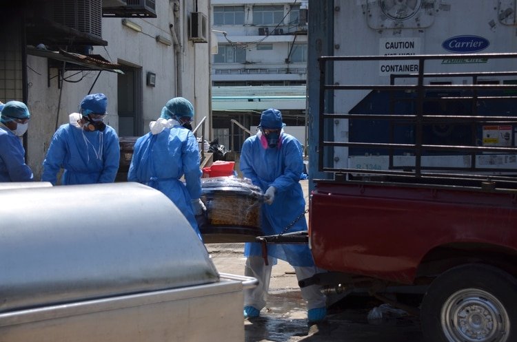 Health workers wearing protective gear load a coffin onto the back of a pick-up truck outside of Teodoro Maldonado Carbo Hospital amid the spread of the coronavirus disease (COVID-19), in Guayaquil, Ecuador April 3, 2020. Picture taken April 3, 2020. REUTERS/Vicente Gaibor del Pino NO RESALES. NO ARCHIVES