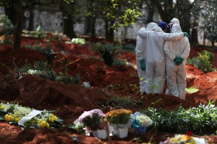 Sepultureros con trajes protectores se reúnen en el cementerio de Vila Formosa, el cementerio más grande de Brasil, durante el brote de la enfermedad por coronavirus (COVID-19), en São Paulo, Brasil. 2 de abril de 2020. REUTERS/Amanda Perobelli.