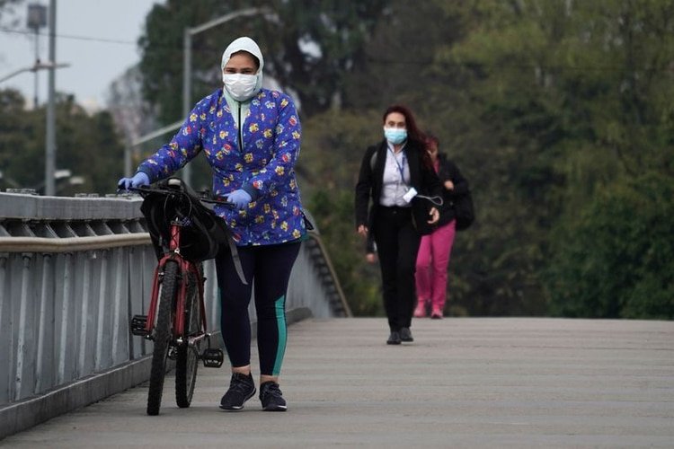 Personas usando tapabocas durante el aislamiento preventivo obligatorio decretado por el gobierno para frenar la expansión del coronavirus caminan sobre un puente peatonal en Bogotá, Colombia, 20 de marzo, 2020. REUTERS/Nathalia Angarita. NO VENTAS NO ARCHIVOS