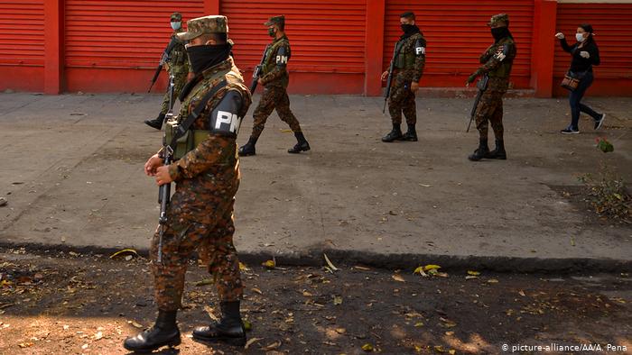 Soldados hacen guardia en una protesta contra el cierre de los centros de ayuda que distribuyeron un subsidio otorgado por el gobierno para la compra de alimentos durante el brote de la pandemia de coronavirus, en San Salvador (30.03.2020)